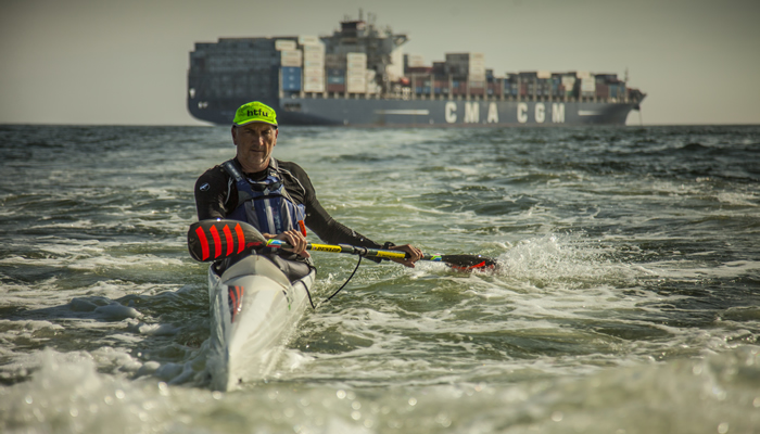 Richard Kohler paddling past a container ship near iSimangaliso