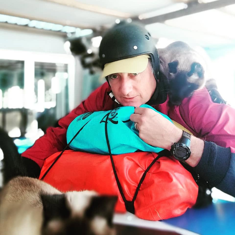 Richard Kohler packing gear with the family cat looking on