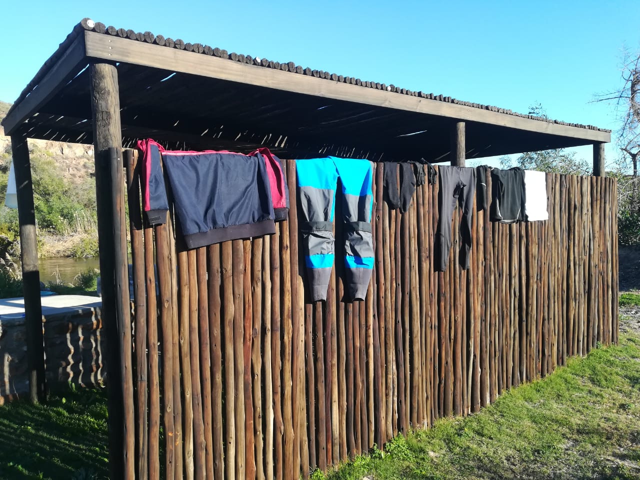 Wet paddling gear hung out to dry on the campsite fence